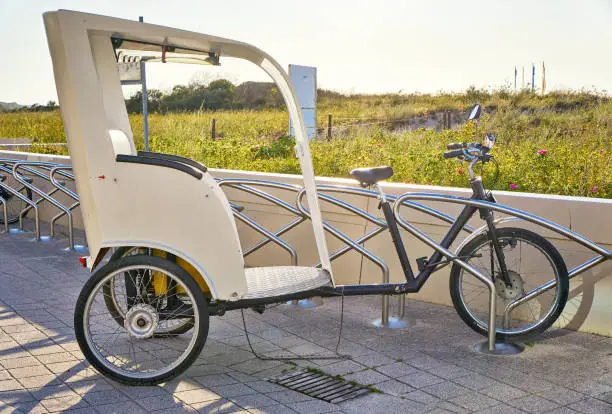 Modern bicycle rickshaw to transport tourists and vacationers on the beach.