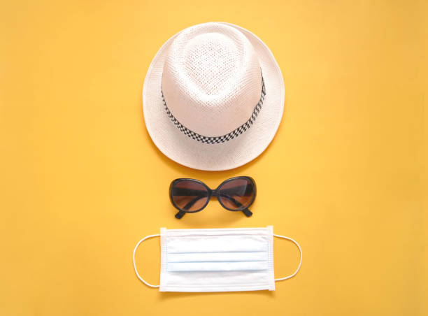 istock Protective medical mask with hat and sunglasses on yellow background 1273599663