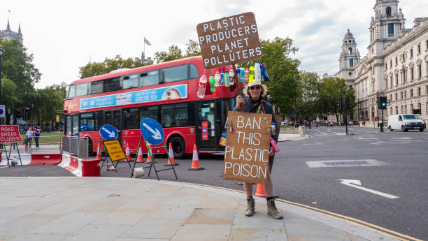 Plastic Producers Planet Polluters Parliament Square, London - 19 September 2020. 
A protester standing on a corner near the Parliament building in Westminster holding placard Plastic Producers Planet Polluters extinction rebellion photos stock pictures, royalty-free photos & images