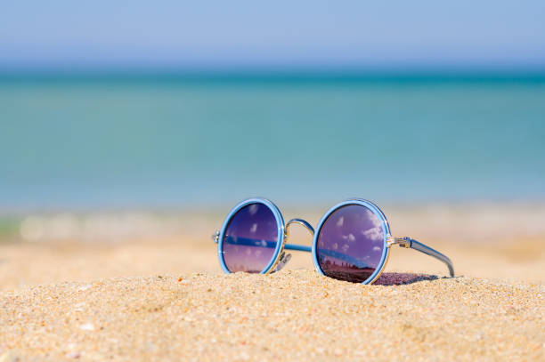 istock Sunglasses lie on the sand by the sea. 1273603737