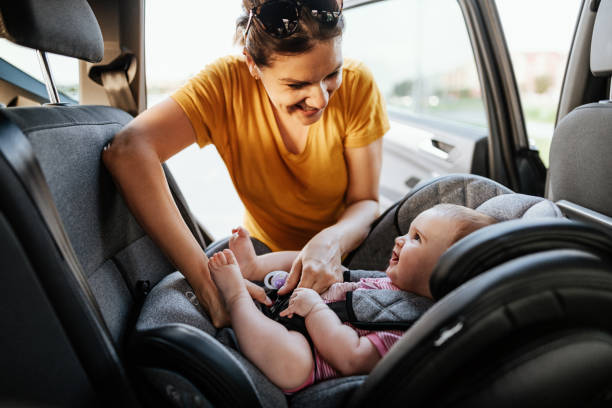 어머니는 차에 아이 좌석에 아기 소녀를 넣어 - travel baby people traveling family 뉴스 사진 이미지