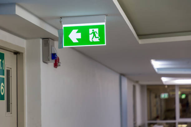 istock Green emergency exit sign showing the way to escape. Fire exit in the building. 1273605055