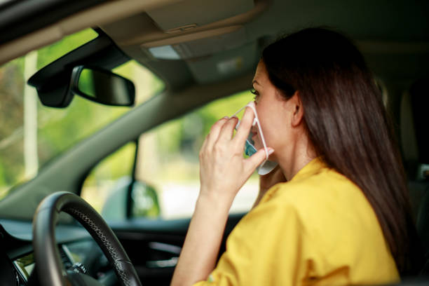 istock Woman with face protective mask in a car 1273608095
