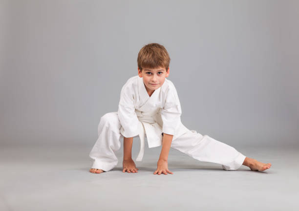 istock Karate boy in white kimono fighting 1273609563
