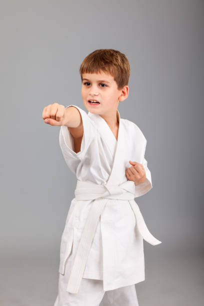istock Karate boy in white kimono fighting 1273609572