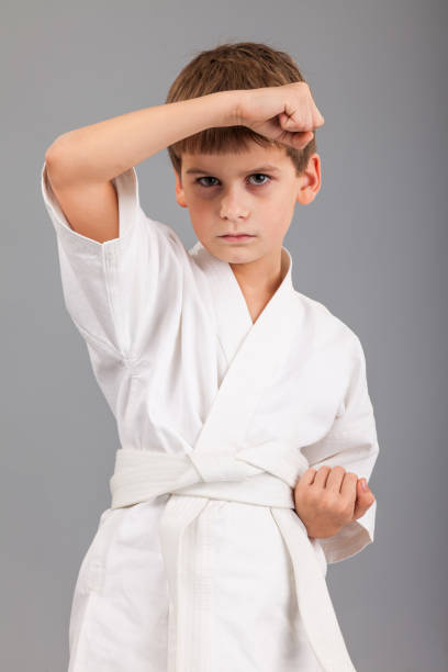 istock Karate boy in white kimono fighting 1273609614