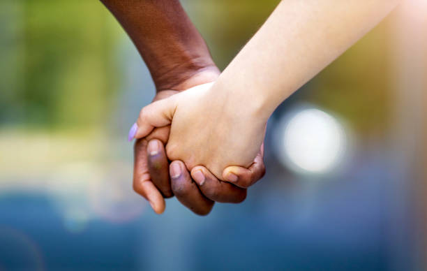 Interracial couple holding hands outdoors Interracial couple holding hands outdoors clingy girlfriend stock pictures, royalty-free photos & images