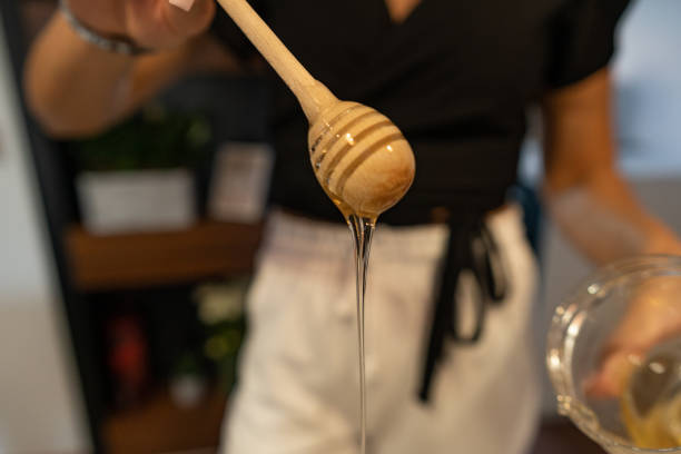 istock Honey slides down from wooden dipper 1273618051