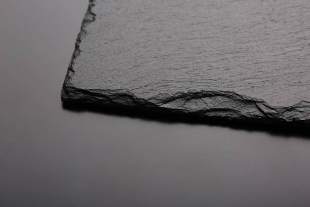 istock Black slate stone on black board. Background or texture. Top view 1273628843