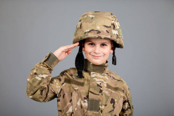istock Saluting soldier. Young boy dressed like a soldier 1273629240
