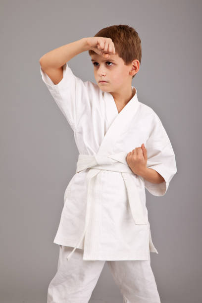 istock Karate boy in white kimono fighting 1273640250