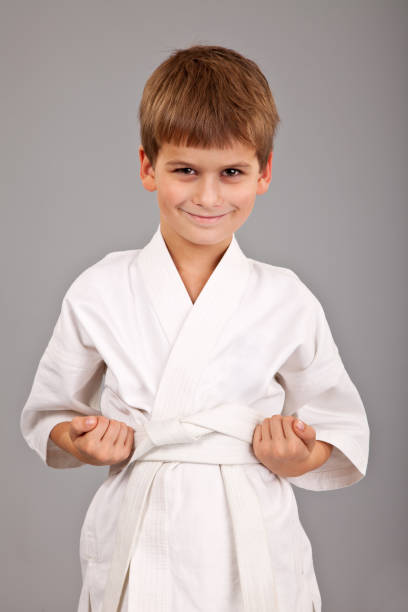 istock Karate boy in white kimono fighting 1273640299