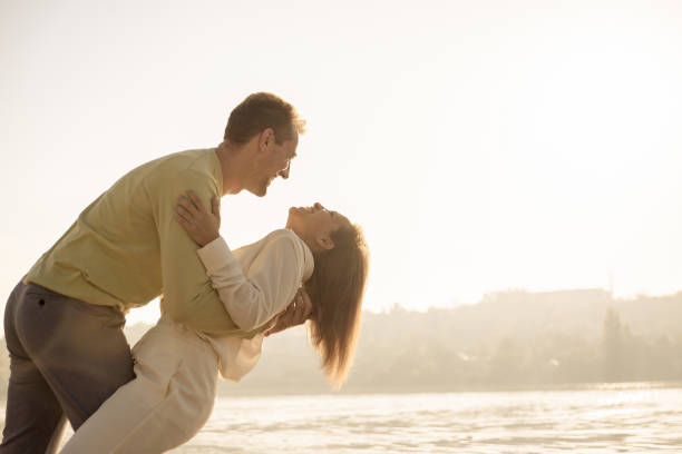 istock loving couple having fun by the river at sunset 1273646261