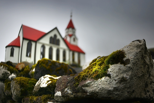 Fisheye lowangle defocused shot of Sandavágs kirkja (church) on a cloudy rainy day in Sandavágur, Faroe Islands.