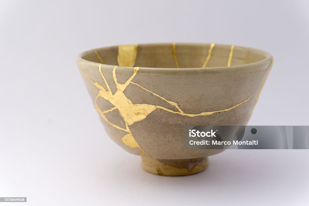 Kintsugi Japanese antique ceramic bowl Gold cracks restoration on old Japanese pottery restored with the antique Kintsugi restoration technique. The beauty of imperfections. Kintsugi Stock Photo