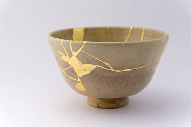 Kintsugi Japanese antique ceramic bowl Gold cracks restoration on old Japanese pottery restored with the antique Kintsugi restoration technique. The beauty of imperfections. 50th anniversary photos stock pictures, royalty-free photos & images