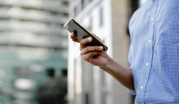 istock a Businessman Using Mobile Phone in the City. Cropped image, selective focus on Smartphone 1273657447