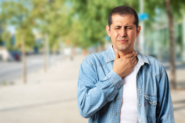 man feels bad with sore throat The man feels bad and coughs as a symptom of a cold or bronchitis on the outside. Health concept. gastroesophageal reflux disease photos stock pictures, royalty-free photos & images