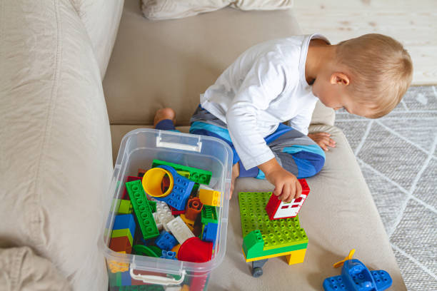 istock Child playing with toy blocks sitting on sofa 1273660333
