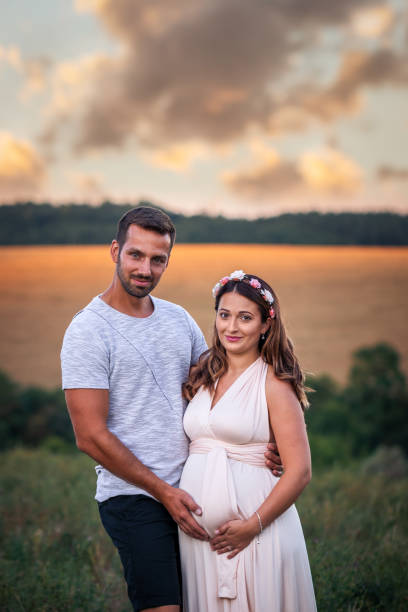 istock Pregnant woman with her husband at sunset 1273661285