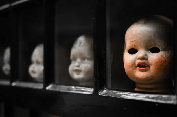 head of scary doll in window