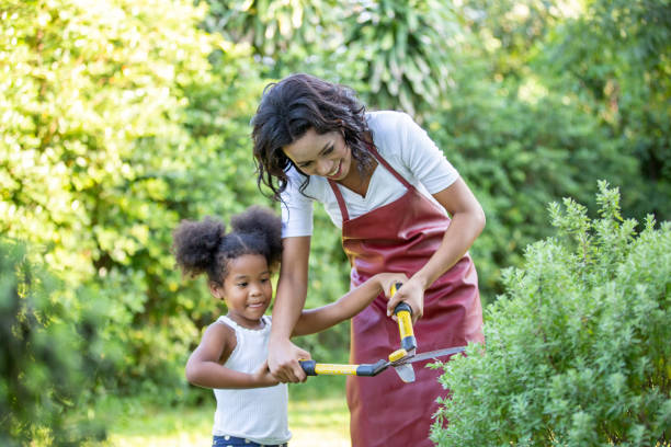 istock Mother And Daughter Cutting Plants In Yard 1273665828