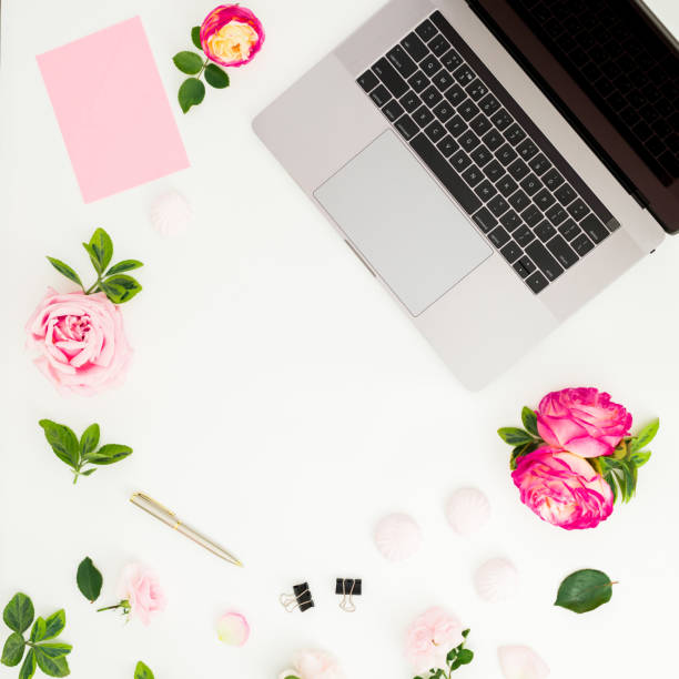 istock Laptop with roses flowers and copy space on white background. Flat lay. Top view. 1273667147