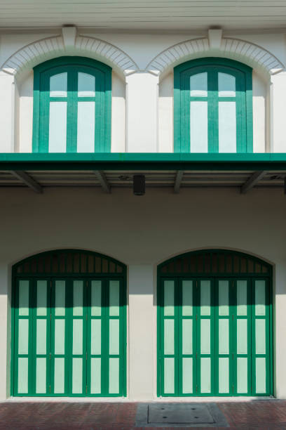 istock green wooden folding arches doors with windows and awning on vintage white building wall 1273670185