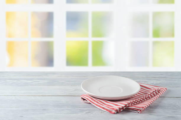 istock Empty plate with striped tablecloth on wooden table over beautiful window background 1273670373