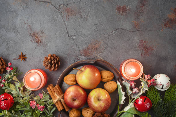 istock Christmas background with apples, walnuts and candles on stone tabletop. Holidays cooking and baking concept 1273670400