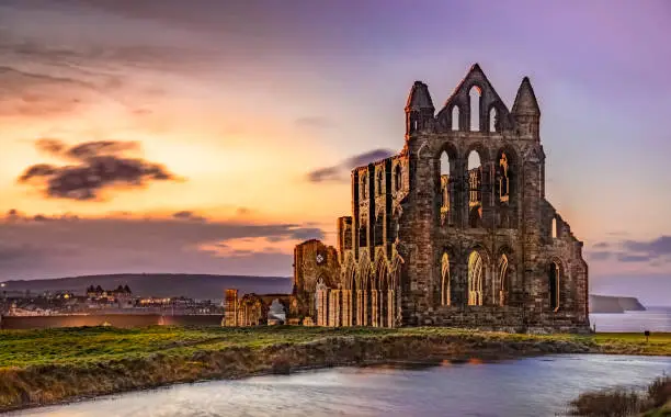 the historic ruins of the abbey above the Yorkshire coastal town of Whitby photographed in evening light