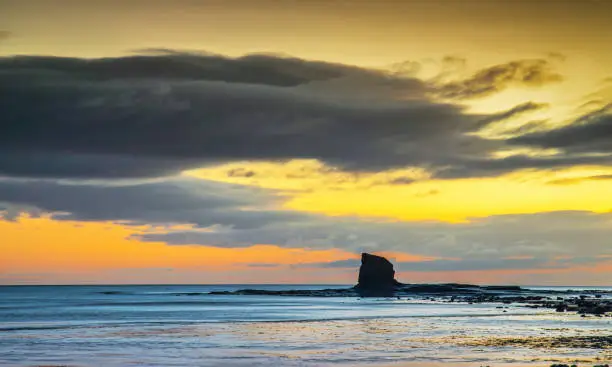 Sunrise images showing the rock stack 'Black Nab' a natural feature on the Yorkshire coast at Saltwick Bay near Whitby