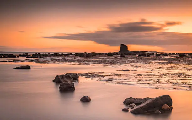 Sunrise images showing the rock stack 'Black Nab' a natural feature on the Yorkshire coast at Saltwick Bay near Whitby
