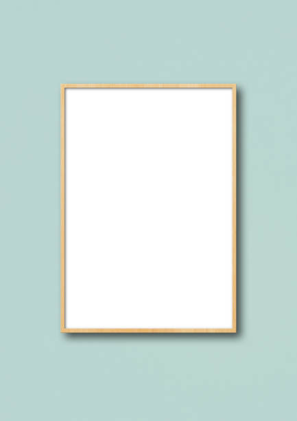 istock Wooden picture frame hanging on a light blue wall 1273674073