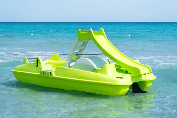grünes tretboot auf sardischem meer in einem türkisfarbenen meer. pedalboot - pedal boat stock-fotos und bilder
