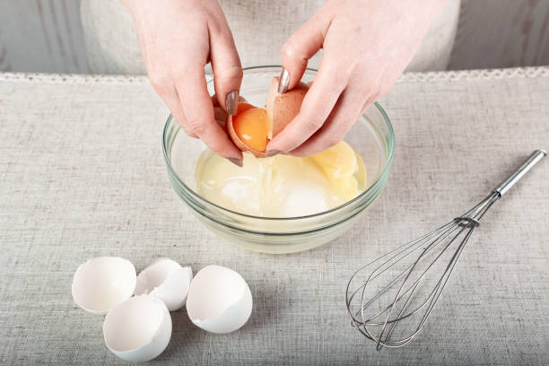 istock the chef's hands hold a raw broken egg over a glass bowl of sugar 1273676035