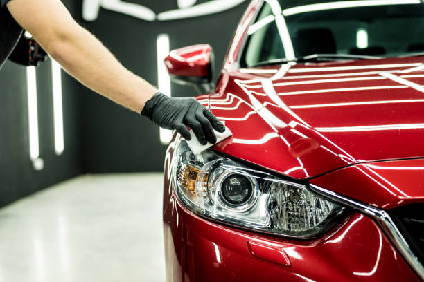 Car service worker applying nano coating on a car detail. Car service worker applying nano coating on a car detail taking off activity photos stock pictures, royalty-free photos & images