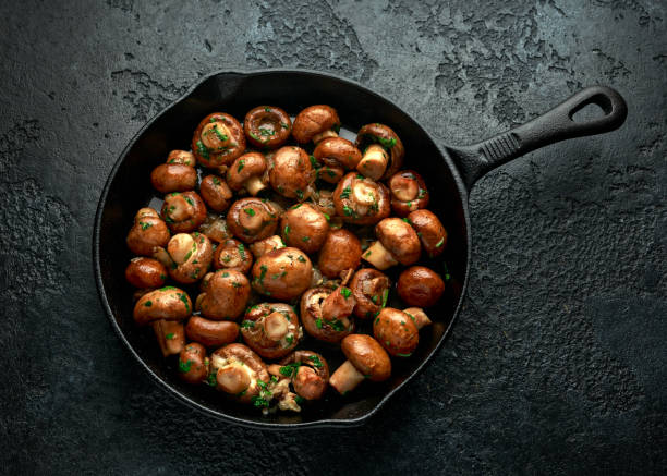 istock Fried mushrooms with onion and garlic in iron cast pan 1273683534
