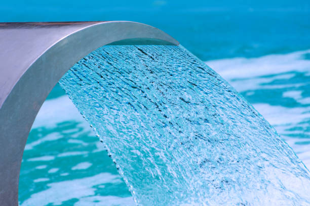 Swimming pool waterfall jet. Close up photo. Selective focus.