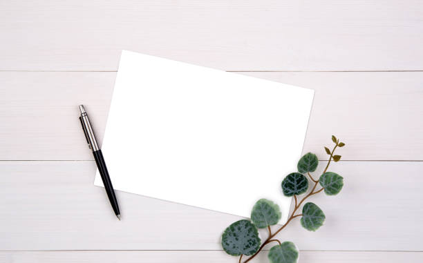 istock Blank paper sheet copy space with mockup and leaf on wooden table, poster and invitation, postcard decoration your design or branding, simplicity and minimal, nobody, flat lay, top view. 1273687708