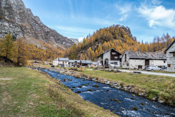 The colours of autumn at the Alpe Devero in Crampiolo, little village in the mountains near a river stock photo