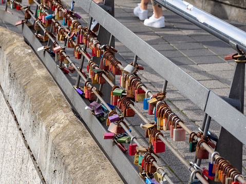 many different padlocks hang on a bridge