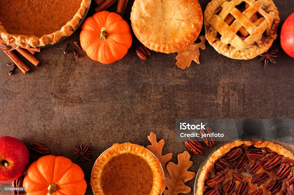 Assortment of homemade autumn pies. Double border on a dark stone background. Assortment of homemade autumn pies. Pumpkin, apple and pecan. Overhead view double border on a dark stone background with copy space. Thanksgiving - Holiday Stock Photo