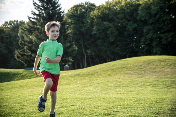 mały chłopiec biegający po trawie na ogromnym polu golfowym - golf child sport humor zdjęcia i obrazy z banku zdjęć