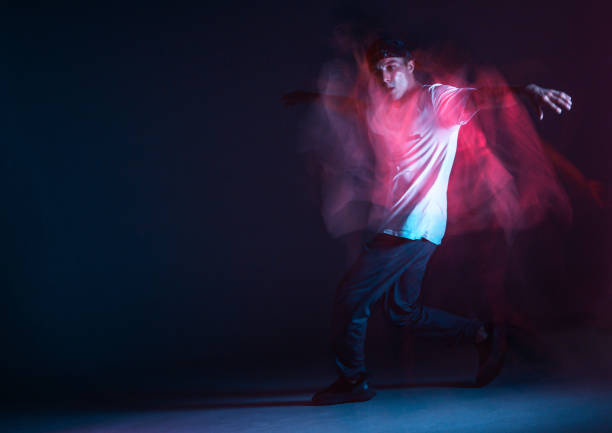 istock Stylish young guy breakdancer dancing hip-hop in neon light. Dance school poster. Long exposure shot 1273701401