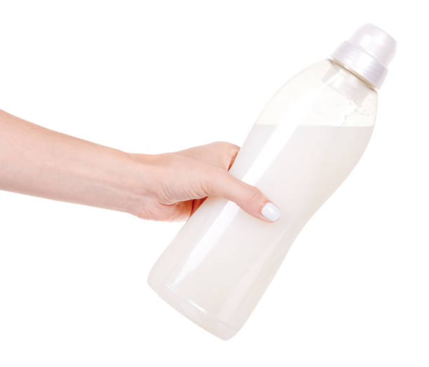 istock Hand with laundry detergent in bottle, isolated on white background. 1273701484