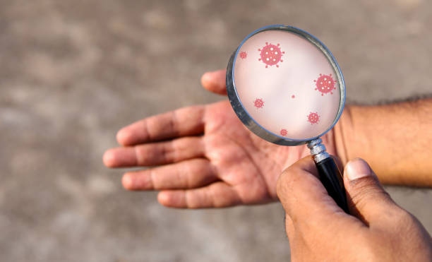 istock Man holding magnifying glass and check hand. hand watch and germs on hands concepts 1273701587