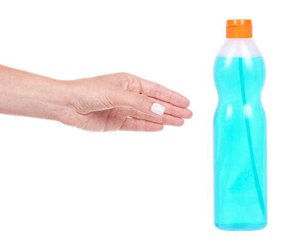 istock Hand with blue window cleaner in bottle, isolated on white background. 1273704490