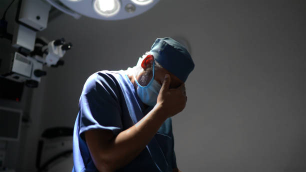 обеспокоенная медсестра-медик в операционной в больнице - doctor tired protective workwear sadness стоковые фото и изображения