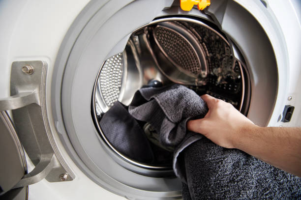 Loading dirty cloth in washing machine Loading dirty cloth in washing machine close up view washing machine drum stock pictures, royalty-free photos & images